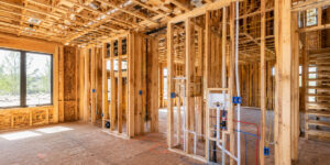 Interior framing stage of a custom home build in Alberta showing wiring, plumbing, and pre-drywall construction